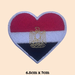 May include: Red, white, and black heart-shaped embroidered patch with the Egyptian flag and coat of arms. The patch measures 6.5 inches by 7 inches.