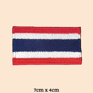May include: A red, white, and blue embroidered patch of the Thai flag. The patch is 7 inches by 4 inches.