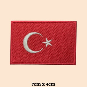 May include: Red embroidered patch featuring a white crescent moon and star, representing the Turkish flag. The patch measures 7cm by 4cm.
