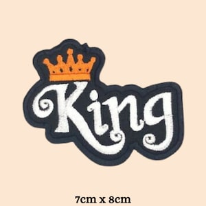 Pode incluir: Etiqueta de ferro preta com o texto "King" bordado em branco e uma coroa bordada laranja acima do texto. A etiqueta mede 7 cm por 8 cm.