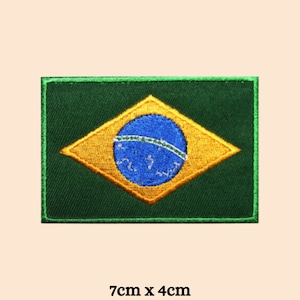 Könnte beinhalten: Grün-gelber gestickter Aufnäher der brasilianischen Flagge. Die Flagge zeigt einen blauen Kreis mit weißen Sternen in der Mitte einer gelben Raute. Der Aufnäher ist 7 cm x 4 cm groß.
