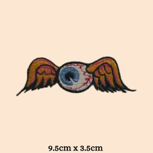 Puede incluir: Un parche bordado con un gran ojo blanco con venas rojas y un iris azul. El ojo está rodeado por dos alas marrones con acentos rojos. El parche mide 9,5 cm por 3,5 cm.