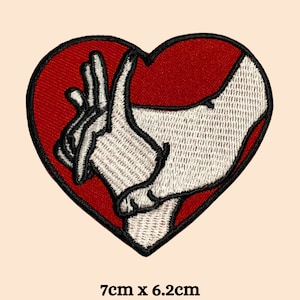 May include: Red heart-shaped patch with white embroidered hands inside. The patch measures 7 inches by 6.2 inches.