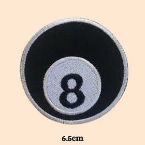 Könnte beinhalten: Schwarz-weiß gestickter Patch einer Billardkugel mit der Nummer 8 in der Mitte. Der Patch hat einen Durchmesser von 6,5 cm.