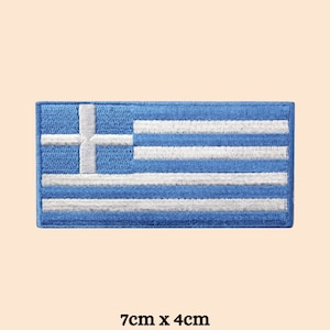 May include: An embroidered patch of the Greek flag, blue and white in colour. The flag measures 7 cm by 4 cm.