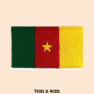 May include: An embroidered patch of the flag of Cameroon. The flag is green, red, and yellow with a yellow star in the center. The patch is 7 cm by 4 cm.
