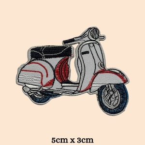 May include: A white and red embroidered iron-on patch of a vintage scooter. The scooter is 5 cm by 3 cm.