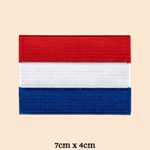 Peut inclure: Un patch brodé du drapeau néerlandais, avec les couleurs rouge, blanc et bleu. Le patch mesure 7 cm sur 4 cm.