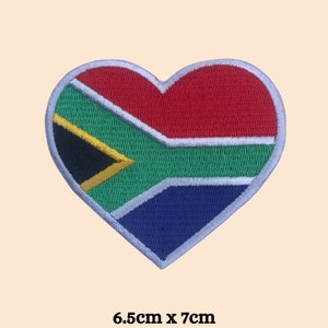 May include: A heart-shaped patch with the South African flag embroidered on it. The flag is red, yellow, green, black, and blue. The patch is 6.5 inches by 7 inches.