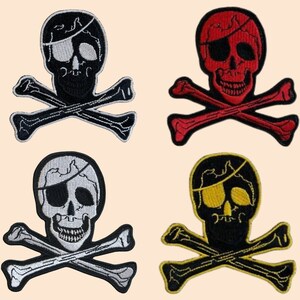 May include: Four embroidered iron-on patches featuring a skull and crossbones design. The patches are in black and white, red and white, yellow and black, and black and white. Each patch features a skull with a single eye patch.