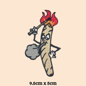 May include: An embroidered patch depicting a cartoon joint with a face, holding a match to light itself on fire. The joint is wearing a hat and has a cloud of smoke coming out of its mouth. The patch measures 9.5cm by 5cm.