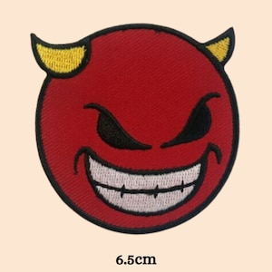 Puede incluir: Parche rojo bordado para planchar con un emoji de diablo con cuernos amarillos y una sonrisa blanca. El parche tiene un diámetro de 6,5 cm.