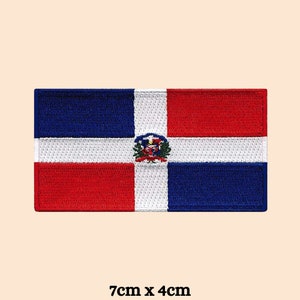 May include: Embroidered patch of the Dominican Republic flag. The rectangular patch features a white cross dividing the flag into four sections: red, blue, white, and blue. The Dominican Republic coat of arms is in the centre. The patch measures approximately 7cm x 4cm.