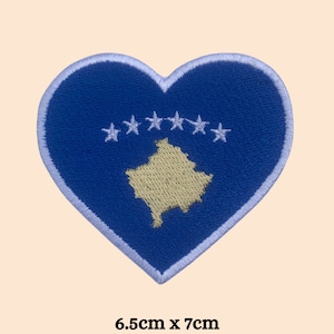 May include: Blue heart-shaped embroidered patch with the flag of Kosovo. The flag features a yellow outline of the country's map and six white stars in a circle.