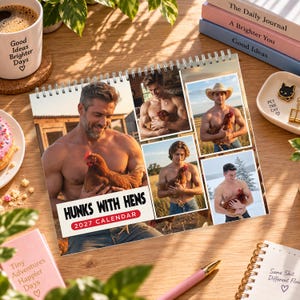 May include: A 2027 wall calendar titled Hunks With Hens featuring multiple photographs of shirtless men holding chickens. The calendar is spiral-bound and displays various outdoor settings, including a farm and a snowy landscape, with a white cover.