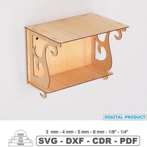 May include: A laser-cut wooden shelf with decorative scrollwork on the sides. The shelf is rectangular with a small bottom shelf and a top. The text "DIGITAL PRODUCT" and "SVG - DXF - CDR - PDF" are visible.