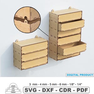 May include: Two light-colored wooden wall-mounted storage units with multiple drawers, featuring laser-cut joinery. A circular inset shows the mounting mechanism. Text includes "DIGITAL PRODUCT", "3 mm - 4 mm - 5 mm - 6 mm - 1/8" - 1/4"", and "SVG - DXF - CDR - PDF".
