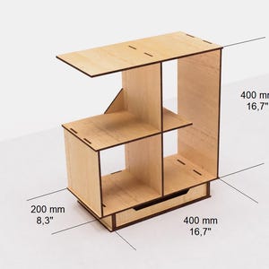 May include: A wooden shelf unit with four compartments and a drawer. The shelf is 16.7 inches wide and 8.3 inches deep. The shelf is made of light wood and has a natural finish.