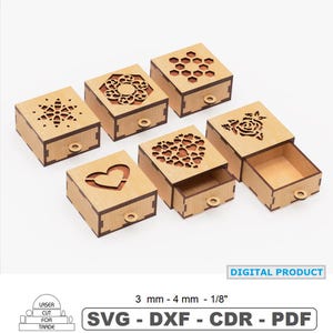 May include: A collection of small, laser-cut wooden boxes with decorative cut-out designs on the lids. The boxes feature various patterns, including a snowflake, a heart, a flower, and geometric shapes. Each box has a small, round pull. The text "DIGITAL PRODUCT" is visible.