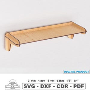 Puede incluir: Una estantería de madera clara con un diseño rectangular, montada en una pared blanca. La estantería tiene un borde elevado y está soportada por dos soportes. La imagen incluye el texto "DIGITAL PRODUCT" y "LASER CUT FOR TRADE".