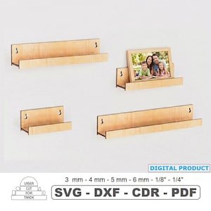 May include: A white ceramic mug with a black handle and the text "But First, Coffee" in a bold, black font. The mug is set against a blurred background, suggesting a cozy setting.