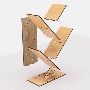 May include: A wooden shelf unit with five pieces, each with a different shape and size. The pieces are made of light brown wood and have a natural finish. The shelf unit is designed to be assembled and can be used to display books, plants, or other decorative items.