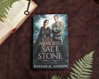 May include: A fantasy novel cover with a dark blue background featuring a man and woman standing in a forest. The title of the book is "Memories of Salt and Stone: Legends of Emyr" by Maegan M. Simpson.