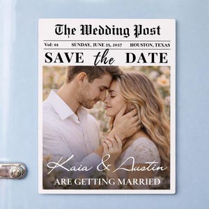 Puede incluir: Un imán rectangular blanco con un diseño temático de periódico. El titular dice "The Wedding Post" con la fecha "DOMINGO, 25 DE JUNIO DE 2027". Debajo, el texto "SAVE the DATE" se muestra sobre una foto de una pareja. Los nombres "Kaia & Austin" están presentes.