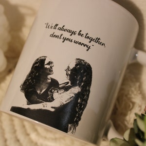 Pode incluir: Caneca de cerâmica branca com uma foto em preto e branco de duas pessoas se abraçando. A caneca tem o texto "We'll always be together, don't you worry." impresso nela.