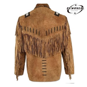 May include: A brown suede jacket with fringe detailing and a black embroidered design on the shoulders. The jacket has a zipper closure and a stand-up collar.