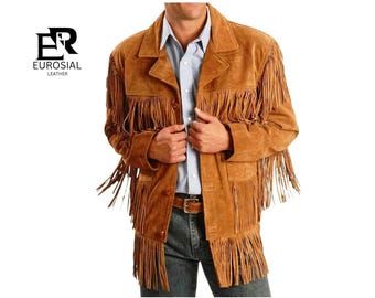May include: A tan suede leather jacket featuring long fringe detailing across the chest, sleeves, and hem. The jacket has a collared neckline, a button-front closure, and is worn over a light blue button-down shirt and dark jeans. Logo reads EUROSIAL LEATHER.