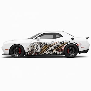 May include: A white two-door coupe featuring a large side decal of a snarling white tiger head integrated with stylized black and red claw marks and white ocean waves. The vehicle has black multi-spoke wheels with visible red brake calipers.
