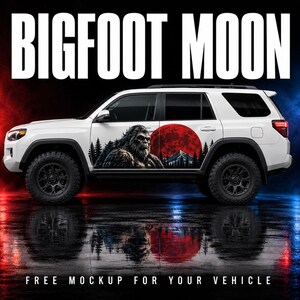 May include: A white SUV featuring a large graphic decal on the side door. The decal depicts a brown Bigfoot creature standing in a forest with a large red moon and mountain silhouette behind it. The text BIGFOOT MOON appears at the top of the image.