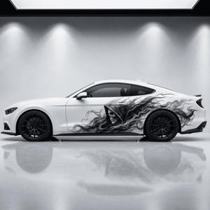 May include: A white sports car featuring a large, detailed black and gray graphic decal on the side panel. The artwork depicts a hooded skull surrounded by swirling, smoke-like patterns that extend toward the rear of the vehicle's body.