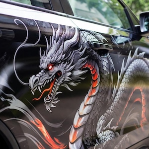 Könnte beinhalten: Schwarze Autotür mit einem detaillierten Drachenmotiv. Der Drache ist hauptsächlich silber und weiß mit roten Akzenten und einem feurigen orangefarbenen Bauch. Der Drachenkopf ist deutlich zu sehen, mit offenem Maul und sichtbarer Zunge.
