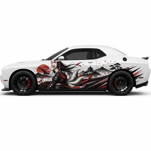 May include: A white sports car featuring a side decal of a figure wearing a fox mask, with long flowing hair and multiple tails. The graphic includes a red sun, a pagoda, mountains, and pine trees, accented by sharp red and black motion lines.