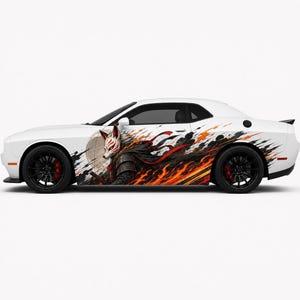 May include: A white two-door coupe featuring a large side decal of a fox-masked samurai warrior in dark armor. The graphic includes dynamic orange and red flames, black smoke, and a circular moon motif, complemented by black wheels and red brake calipers.