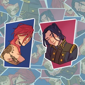 May include: Two stickers with illustrations of characters. One features a character with red hair and a tattoo on their arm, set against a blue background. The other has a character with dark hair, set against a red background. The stickers have detailed facial features.