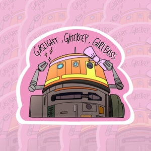 Peut inclure: Autocollant représentant un robot de dessin animé avec l'inscription "GASLIGHT, GATEKEEP, GIRL BOSS". Le robot est orange et gris, avec un nœud rose. Le fond est rose clair avec du texte et des illustrations de robots répétés.