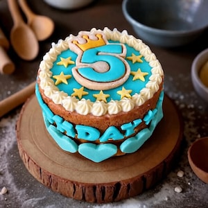 May include: A round cake decorated with blue frosting, a large number five, a yellow crown, and yellow stars on top. The sides feature white piped frosting, blue heart-shaped decorations, and blue letters spelling out the word BIRTHDAY.
