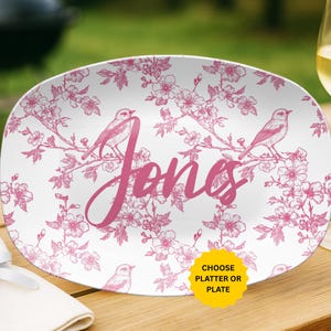 May include: White oval platter with a pink floral and bird design. The word "Jones" is written in pink script across the center. A yellow sticker in the corner says "Choose Platter or Plate."