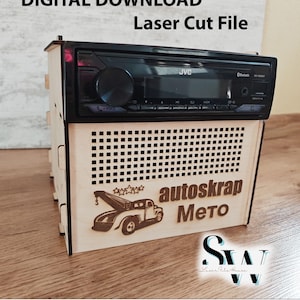Puede incluir: Una caja de madera cortada con láser con una radio de coche JVC instalada. El panel frontal presenta el texto "autoskrap Мето" y un gráfico de una grúa. El texto superior dice "DESCARGA DIGITAL Archivo de corte láser".