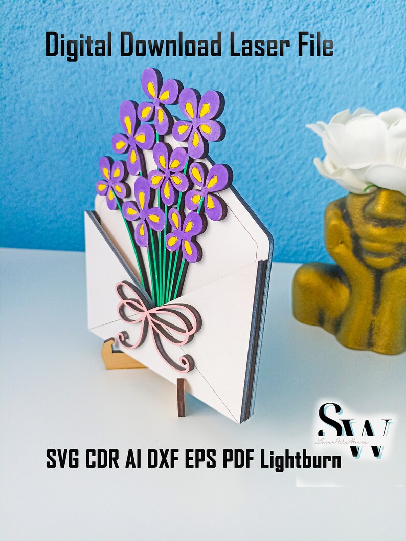 May include: A laser-cut wooden craft project featuring a white envelope with a bouquet of purple flowers with yellow centers and a pink bow. The text reads Digital Download Laser File and SVG CDR AI DXF EPS PDF Lightburn.