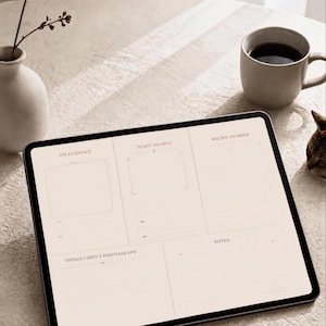以下が含まれることがあります： Tiny Evidence of a Lifeというタイトルのジャーナルテンプレートを表示するデジタルタブレット。画面はTin Evidence、Ticket Archive、Recipe Stories、Things I Didn't Photograph、Notesというラベルのセクションに分かれており、背景は明るいベージュ色です。