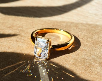 Peut inclure: Une bague de fiançailles en or avec un grand diamant rectangulaire transparent.