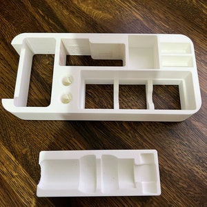 Puede incluir: Organizador de pl&aacute;stico blanco con m&uacute;ltiples compartimentos y una bandeja de pl&aacute;stico blanco separada. El organizador tiene un compartimento largo y estrecho, dos compartimentos cuadrados y tres compartimentos rectangulares m&aacute;s peque&ntilde;os. La bandeja tiene un compartimento largo y estrecho con un extremo redondeado.