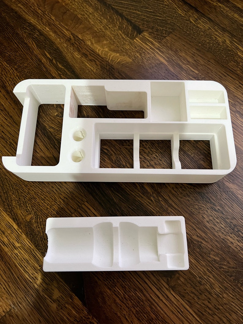 Puede incluir: Organizador de pl&aacute;stico blanco con m&uacute;ltiples compartimentos y una bandeja de pl&aacute;stico blanco separada. El organizador tiene un compartimento largo y estrecho, dos compartimentos cuadrados y tres compartimentos rectangulares m&aacute;s peque&ntilde;os. La bandeja tiene un compartimento largo y estrecho con un extremo redondeado.