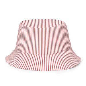 May include: A bucket hat featuring a repeating vertical pinstripe pattern in red and white. The hat has a flat crown and a downward-sloping brim that encircles the entire circumference, maintaining a consistent striped design throughout the fabric.