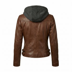 May include: Brown leather jacket with a gray hooded sweatshirt insert. The jacket has a classic design with a zipper closure and two decorative buckles at the waist. The back view shows the stitching details and the texture of the leather.