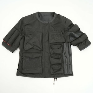 May include: A black short-sleeved jacket featuring a crew neckline and multiple utility pockets of varying sizes on the front. The garment includes a vertical panel on the right side, padded sleeve details with a thin red accent, and a drawstring hem.